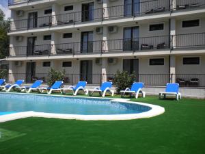 un hôtel avec des chaises bleues et une piscine dans l'établissement Hotel Mondial - Eforie Nord, à Eforie Nord