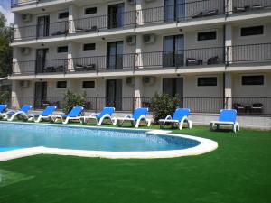 a hotel with blue chairs and a swimming pool at Hotel Mondial - Eforie Nord in Eforie Nord