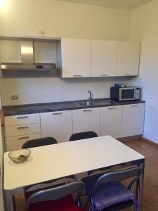 eine Küche mit einem Tisch mit Stühlen und einer Mikrowelle in der Unterkunft Cartiera in Cannobio