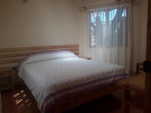 a bed sitting in a room with a window at CASA MACAW in San Pedro de Atacama