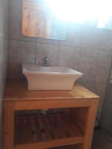 a white sink sitting on top of a wooden table at CASA MACAW in San Pedro de Atacama
