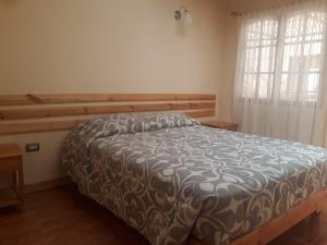 サン・ペドロ・デ・アタカマにあるCASA MACAWのベッドルーム1室(ブラウンと白の掛け布団付きのベッド1台付)