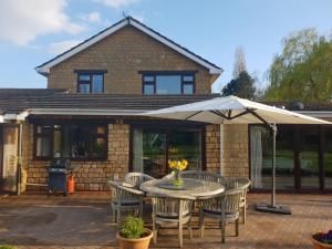 a patio with a table and chairs and an umbrella at Lower grange park in Chacombe