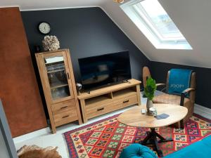 ein Wohnzimmer mit einem TV und einem Tisch in der Unterkunft Ferienwohnungen am Klosterberg in Bad Neuenahr-Ahrweiler
