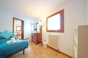 ein Schlafzimmer mit einem blauen Bett und einem Fenster in der Unterkunft Best Venice Terrace in Venedig