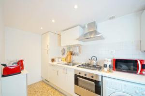 a kitchen with white cabinets and a stove top oven at Best Venice Terrace in Venice