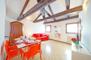 uma sala de jantar com uma mesa e cadeiras laranja em Best Venice Terrace em Veneza