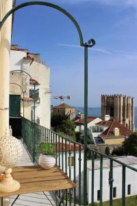 einen Balkon mit einer Holzbank und Stadtblick in der Unterkunft Retrato de Lisboa in Lissabon