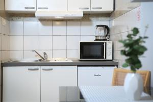 eine Küche mit einer Spüle und einer Mikrowelle in der Unterkunft SPLIT CHIC Studio in Split