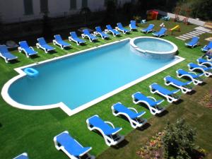 un grupo de sillas y una piscina en Hotel Mondial - Eforie Nord, en Eforie Nord
