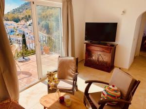 a living room with a television and a table and chairs at Villa Panorama Mijas Pueblo in Mijas