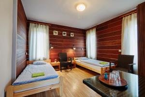 科希策Holiday houses BARCA的客房设有两张床、一张桌子和一张桌子。
