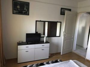 a bedroom with a dresser with a television and a mirror at Apartament Port Turistic Mangalia in Mangalia