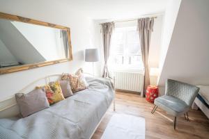 um quarto com uma cama, um espelho e uma cadeira em Villa Golding - Flat 3 em Dresden