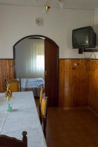 a room with a table and a television on the wall at Apartment Milada in Banjol