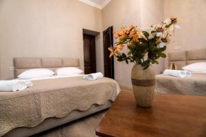 een kamer met 2 bedden en een vaas met bloemen op een tafel bij Star Hotel in Tbilisi City