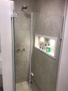 baño con ducha y puerta de cristal en DeROSE Ipanema - quarto no coração de Ipanema, en Río de Janeiro