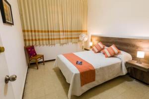 um quarto de hotel com uma cama e uma cadeira em Feel at home in Oaxaca (6) em Oaxaca de Juárez