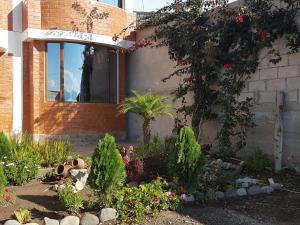 a garden of flowers in front of a house at Hotel Kampak Wasi in Urcuquí