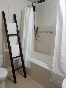 a bathroom with a shower curtain and a toilet at Hotel Kampak Wasi in Urcuquí