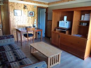 a living room with a microwave and a table at Meares Vista Inn in Tofino