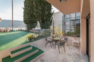 a patio with a table and chairs and a tennis court at Dunja Boka Bay in Herceg-Novi +5 photos