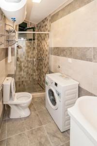 a bathroom with a toilet and a washing machine at Dunja Boka Bay in Herceg-Novi