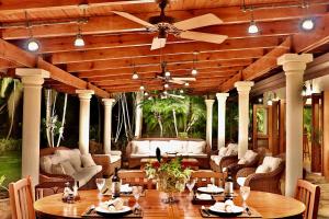 a patio with tables and chairs and a ceiling fan at CASA NOSTRA RESORT by Klabhouse in La Romana