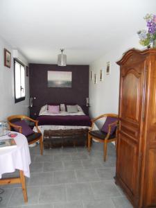 Schlafzimmer mit einem Bett, einem Tisch und Stühlen in der Unterkunft Chambres d'hôtes La Luce in Démuin