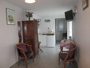 ein Wohnzimmer mit einem Tisch und Stühlen sowie eine Küche in der Unterkunft Chambres d'hôtes La Luce in Démuin