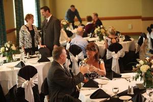 a group of people sitting at tables in a room with white tables at Isle Casino Hotel Waterloo in Waterloo