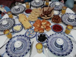 a table with blue and white plates of food at Riad Oumkaltoum Fès in Fez