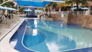 a swimming pool with blue water in a resort at Apartamento Caldas in Caldas Novas +6 photos