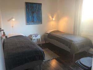 a bedroom with two beds and a painting on the wall at Kajsa krabbat Vandrarhem in Kungshamn