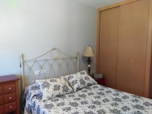 ポルトノボにあるApartamento playa canelasのベッドルーム1室(ベッド1台、ドレッサー、ランプ付)