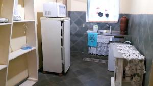eine kleine Küche mit Kühlschrank und Mikrowelle in der Unterkunft Casa dois andares com área de churrasco em Ibitipoca in Conceição da Ibitipoca