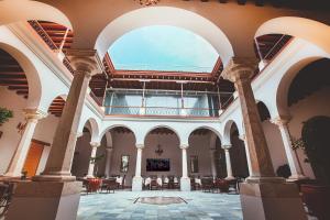 an empty lobby with a large window and tables and chairs at Hotel Parador de Alcalá in Oaxaca City