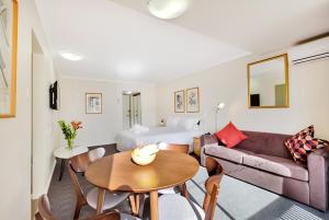 uma sala de estar com um sofá e uma mesa em Renovated Stylish Studio em Sydney