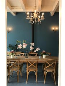 a dining room with a table with chairs and a chandelier at Logies De Reiziger in Groede +56 photos