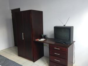 a tv sitting on a dresser next to a cabinet at Casa 10 Guest house in Guatemala