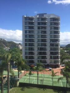 un gran edificio con una pista de tenis enfrente en Burleigh Gardens North Hi-Rise Holiday Apartments, en Gold Coast