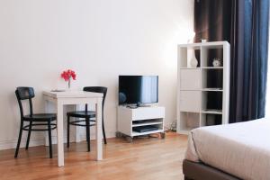 - une chambre avec une table, des chaises et une télévision dans l'établissement Lauriston Nice Studio, à Paris