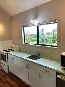 uma cozinha vazia com um lavatório e uma janela em Rayland Epsom Motel em Auckland