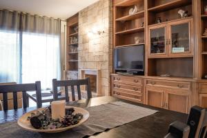 ein Wohnzimmer mit einem Esstisch und einem TV in der Unterkunft Mistral Barcelona Centro in Barcelona