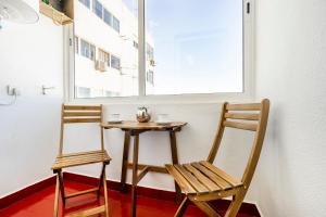 a small table and two chairs next to a window at My Place @ Faro City Views in Faro