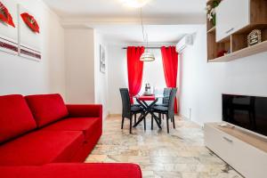 a living room with a red couch and a table at My Place @ Faro City Views in Faro