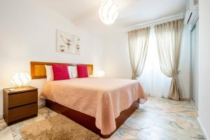 a bedroom with a large bed with red pillows at My Place @ Faro City Views in Faro