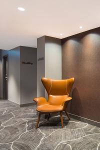 an orange chair in a room with a wall at Jephson Hotel & Apartments in Brisbane