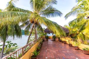 een balkon met palmbomen en uitzicht op de oceaan bij Villa Celeste in Chacala