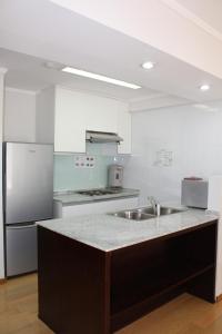 a kitchen with a sink and a refrigerator at Saigon Sky Garden Serviced Apartments in Ho Chi Minh City